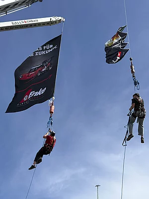 Kran mit Fahne und Menschen auf dem 5. Enke Impulscamp am Nürburgring
